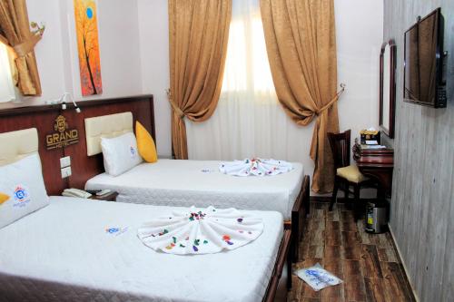 a hotel room with two beds with white sheets at Grand Hotel Ras Elbar in Ras El Bar