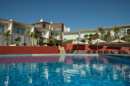 a swimming pool in front of a large building at Marina Mar II - Moradia T3 in Vila Franca do Campo
