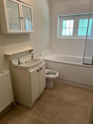 a bathroom with a sink and a toilet and a bath tub at The Stud House at Danebury in Stockbridge