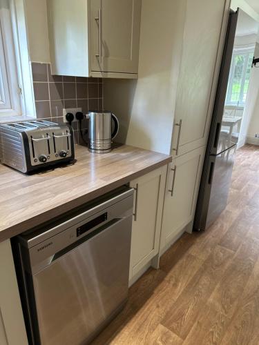 a kitchen with white cabinets and a counter top at The Stud House at Danebury in Stockbridge