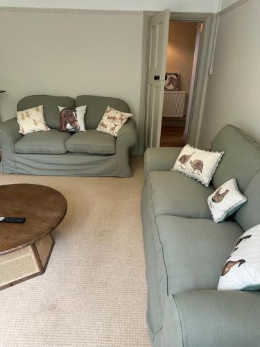 a living room with two couches and a table at The Stud House at Danebury in Stockbridge