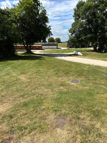 a grassy field with a sidewalk and a road at The Stud House at Danebury in Stockbridge