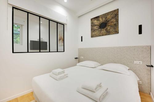 - une chambre blanche avec un grand lit blanc et 2 oreillers dans l'établissement Charming apartment - 3BR-8P -Centre Pompidou, à Paris