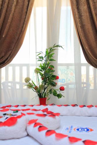 a table with red and white blankets and a plant at Grand Hotel Ras Elbar in Ras El Bar
