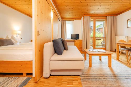 a bedroom with a bed and a chair and a table at Ferienwohnungen Knaller-Möd in Weissensee