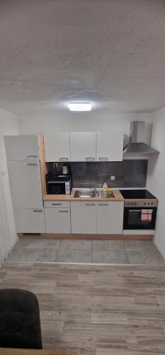 a kitchen with white cabinets and a sink at Guest House Laura in Korenica