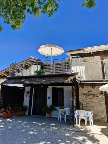 a house with a balcony and an umbrella on top of it at La Dolce Vita in Castelfidardo