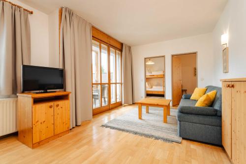 a living room with a couch and a tv at Ferienwohnungen Knaller-Möd in Weissensee