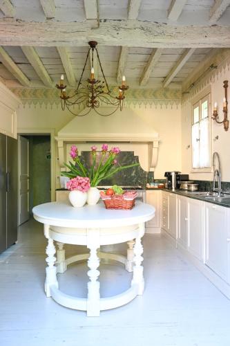 a kitchen with a white table with flowers on it at Elizabeth Country House, a Member of Design Hotels in Minerbio