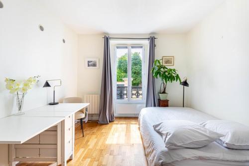 une chambre avec un lit, un bureau et une fenêtre dans l'établissement GuestReady - Cosy stay near Jardin du Luxembourg, à Paris