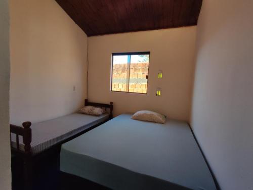 戈亚斯州上帕莱索Cantinho da Lobeira的一间带窗户的小房间里有两张床