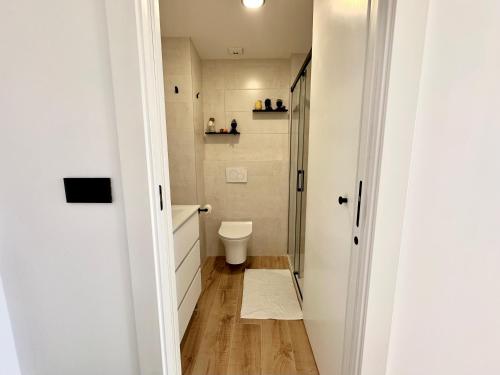 a small bathroom with a toilet and a hallway at Apartamento Bambú in Torre del Mar