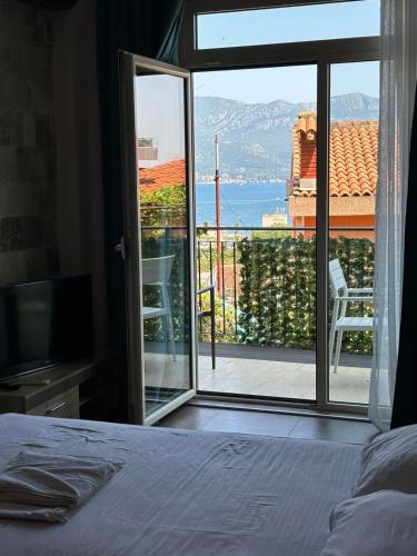 a bedroom with a bed and a view of a balcony at The Old Town Viewpoint Apartments in Budva