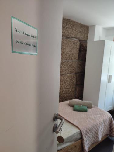 a bedroom with a bed with a sign on the door at Casa Augusta AL in Braga