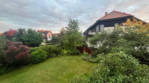 a house with a yard with trees and a fence at Comfy stay at Hill of Clouds in Rāmava