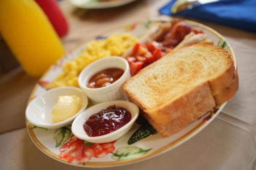 ein Teller Frühstücksspeisen mit einem Sandwich und Rühreiern in der Unterkunft Coco Resort Penida in Nusa Penida