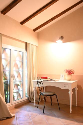 a desk with a chair in a room with a window at Elizabeth Country House, a Member of Design Hotels in Minerbio