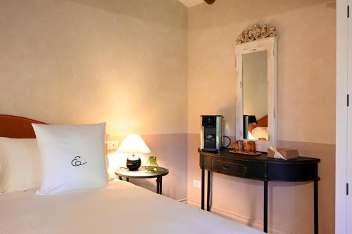 a hotel room with a bed and a mirror at Elizabeth Country House, a Member of Design Hotels in Minerbio