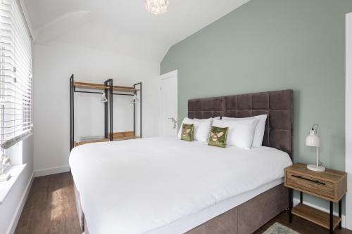 a bedroom with a large white bed with a wooden headboard at Host & Stay - Sanderling Chase in Scarborough