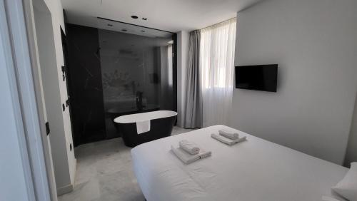 a white bedroom with a bed and a sink at RentalSevilla Real de la Carretería in Seville