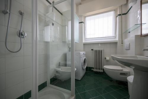 a bathroom with a shower and a toilet and a sink at Breathtaking view. in Malcesine