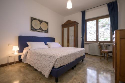 a bedroom with a blue bed and a window at Breathtaking view. in Malcesine
