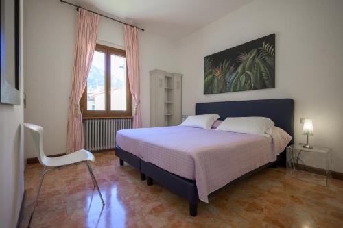 a bedroom with a bed and a chair and a window at Breathtaking view. in Malcesine
