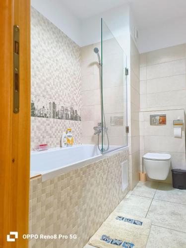 a bathroom with a bath tub and a toilet at Jeni's studio in Constanţa