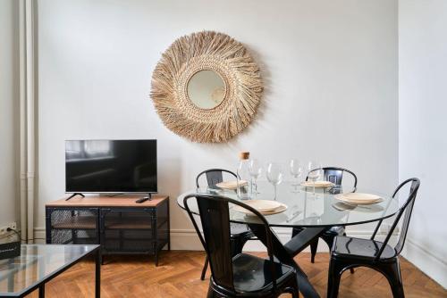 - une salle à manger avec une table, des chaises et un miroir dans l'établissement Appartement a proximité de Lille, à Marcq-en-Barœul