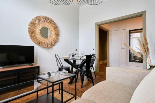 un salon avec une table et une télévision dans l'établissement Appartement a proximité de Lille, à Marcq-en-Barœul