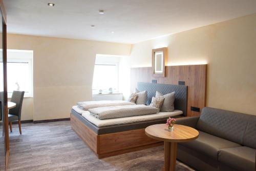 a living room with a couch and a table at Hotel Heideparadies in Soltau