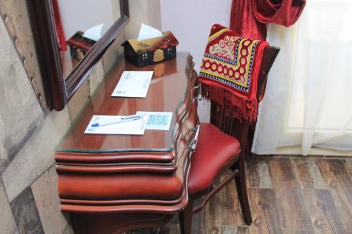 a wooden desk with a chair and a mirror at Grand Hotel Ras Elbar in Ras El Bar