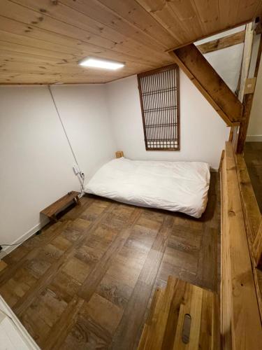 a bedroom with a bed and a wooden floor at Eoulim House in Andong