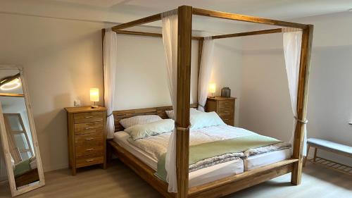 a bedroom with a canopy bed and a mirror at Kurpark Ferienwohnung in Schleiden