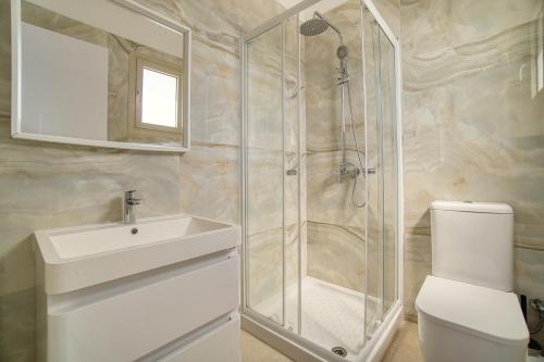 a bathroom with a shower and a sink and a toilet at Tala Sea View 205 in Tala