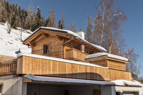 a wooden house with snow on the roof at Troadkasten Chalet Unterkoller in Bischofshofen