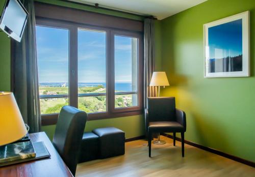 a room with a desk and two chairs and a window at La Colina in Gijón