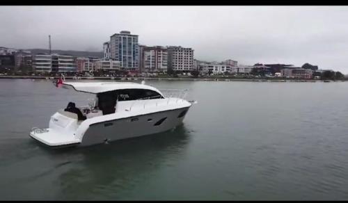 a white boat in the water with a city in the background at Macakizi yat in Atakum