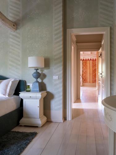 a bedroom with a bed and a table with a lamp at Elizabeth Country House, a Member of Design Hotels in Minerbio