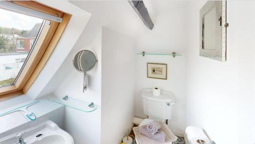 a white bathroom with a sink and a mirror at CROYDE HALLGREIN 4 Bedrooms in Croyde