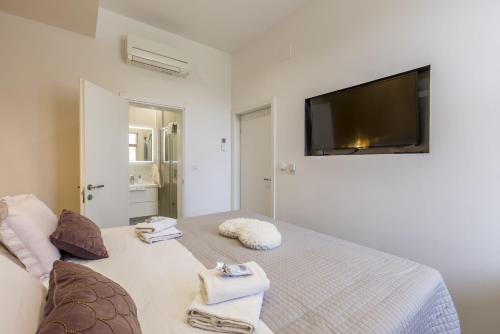 a bedroom with a bed with a flat screen tv on the wall at Zvonimir Holiday with large 95m2 pool in Solin