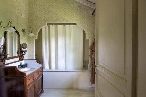 a bathroom with a sink and a shower curtain at Elizabeth Country House, a Member of Design Hotels in Minerbio