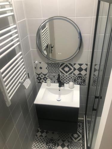 une salle de bain avec un lavabo et un miroir dans l'établissement La Joueuse, Et pop Et Chic !, à Poitiers