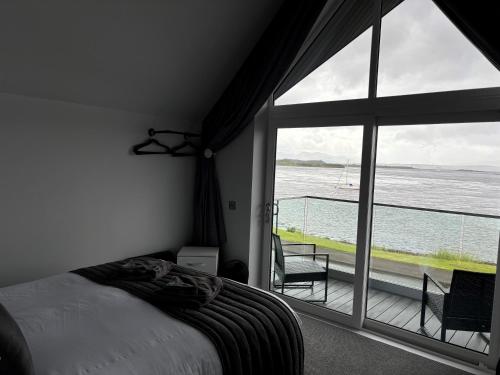 a bedroom with a bed and a view of the water at Oyster Inn Connel in Oban