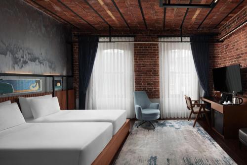 a bedroom with two beds and a desk and a chair at DeCamondo Galata, a Tribute Portfolio Hotel in Istanbul