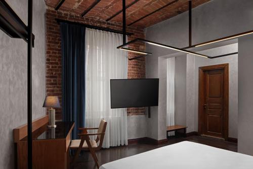 a bedroom with a bed and a tv on the wall at DeCamondo Galata, a Tribute Portfolio Hotel in Istanbul