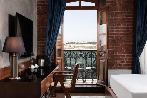 a bedroom with a desk and a bed and a balcony at DeCamondo Galata, a Tribute Portfolio Hotel in Istanbul