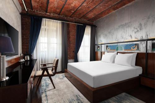 a bedroom with a large white bed and a desk at DeCamondo Galata, a Tribute Portfolio Hotel in Istanbul