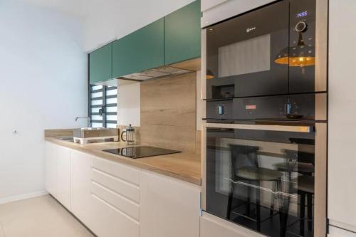 a kitchen with white cabinets and a stove top oven at Blue Nest Luxury Penthouse in Blue Bay