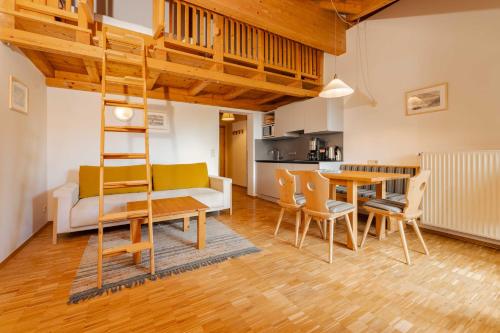 a living room with a table and chairs and a ladder at Ferienwohnungen Knaller-Möd in Weissensee